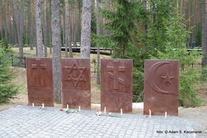 Symbole religii, w głębi cmentarz rosyjski z kładkami nad mogiłami zbiorowymi