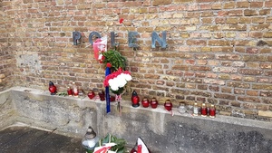 Napis upamiętniający polskie ofiary na murze byłego obozu
