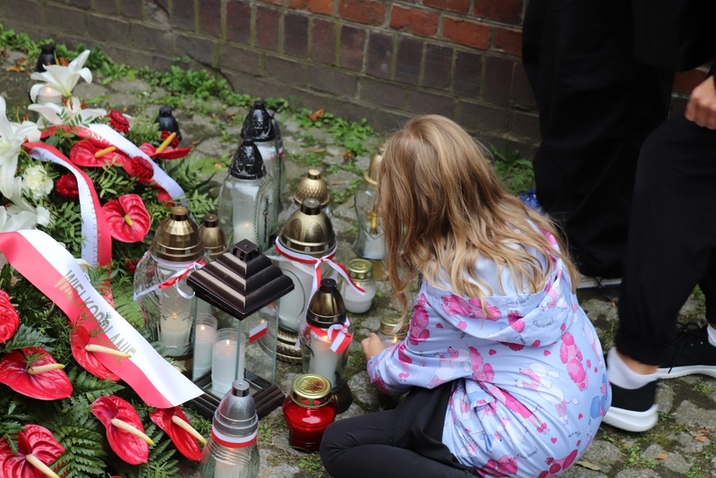 Uczestniczka akcji ze zniczem pamięci pod ścianą straceń Fortu VII