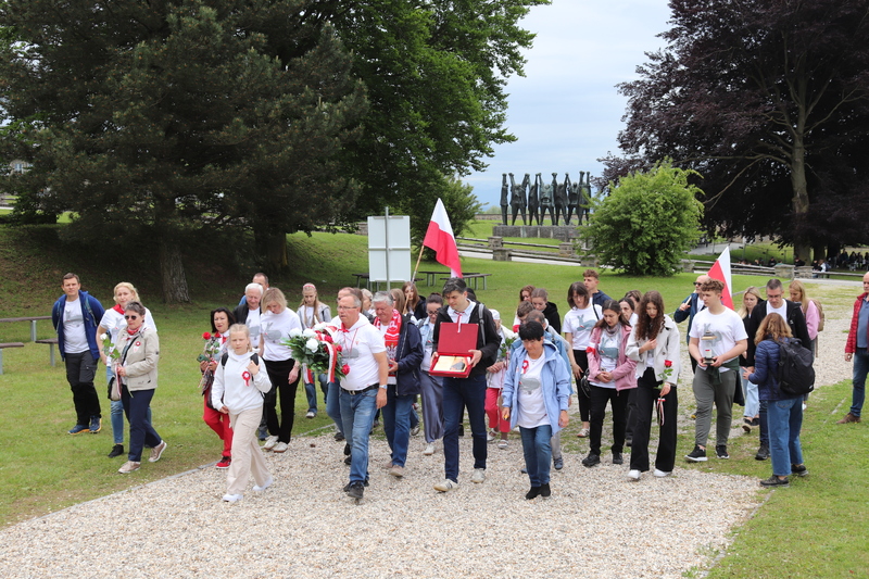 Składanie kwiatów przez członków wyjazdu przed polskim pomnikiem w Miejscu Pamięci Mauthausen. Fot. Tomasz Cieślak (IPN)