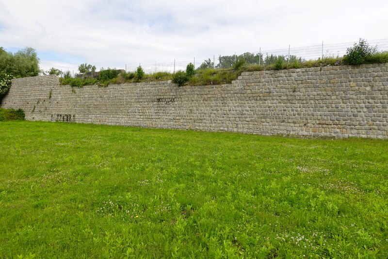 Teren byłego placu apelowego w KL Gusen. Widok na pozostałości muru oporowego zbudowanego przez więźniów KL Gusen. Stan obecny. Fot. Tomasz Cieślak (IPN)