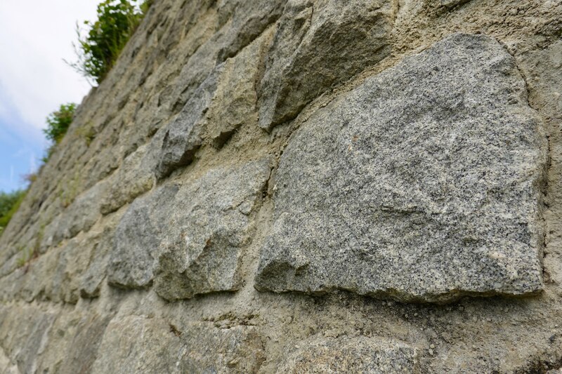 Teren byłego placu apelowego w KL Gusen. Widok na pozostałości muru oporowego zbudowanego przez więźniów KL Gusen. Stan obecny. Fot. Tomasz Cieślak (IPN)