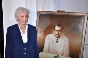 Iwona Hańczewska córka dr. Franciszka Witaszka przy portrecie przedstawiającym jej ojca.
