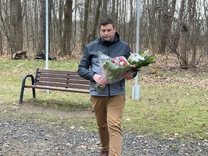 Składanie wiązanek kwiatów pod pomnikiem. Fot. Kamil Hypki
